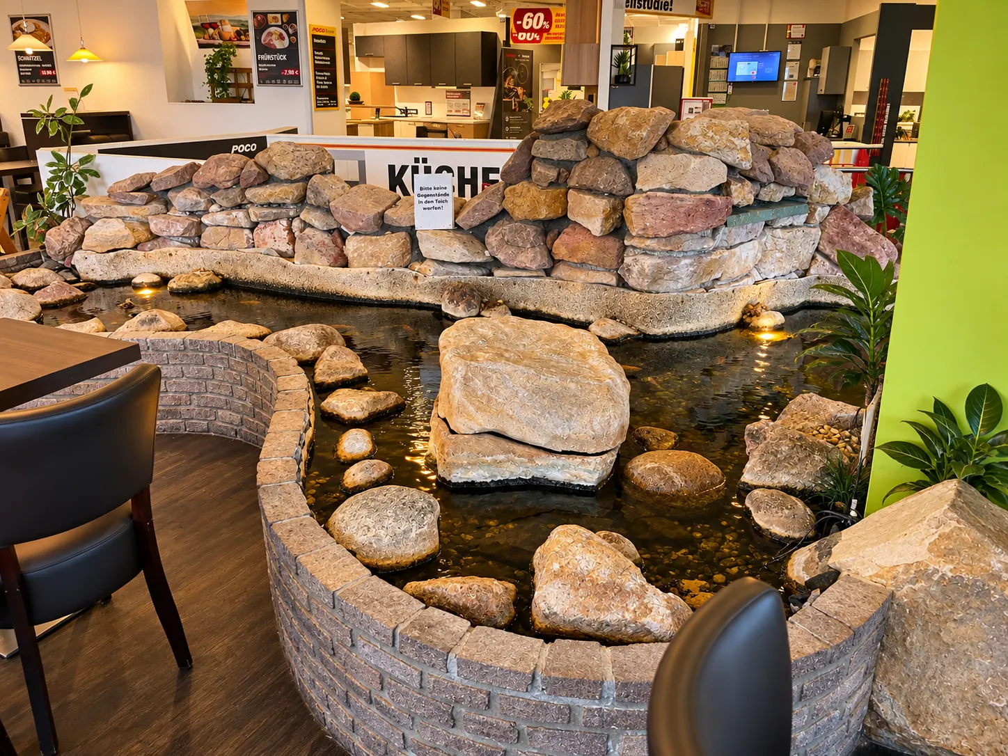 Gemütliche Sitzplätze am dekorativen Wasserbecken im POCO Bistro Hannover